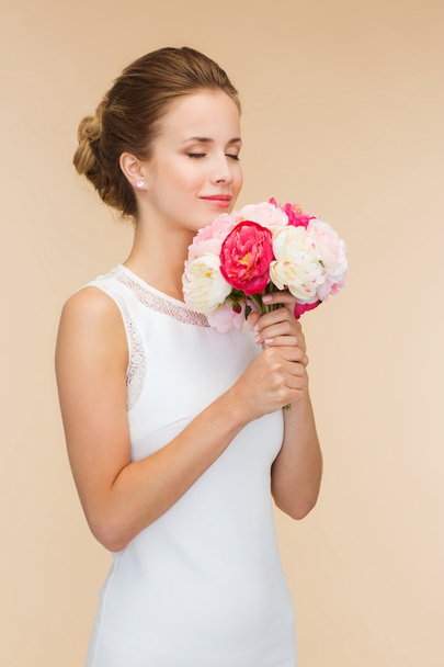 smiling woman in white dress with bouquet of roses - Photo, image