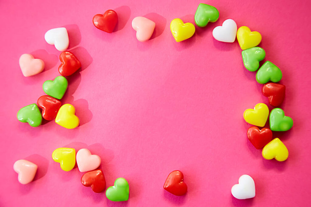 frame of multy-colored hearts on magenty background - Fotó, kép