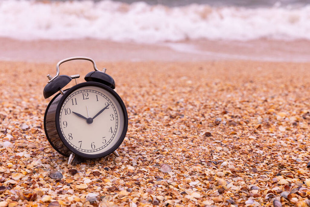 Summer vacation concept. Time to relax. copy space, alarm clock on the beach. - Фото, изображение