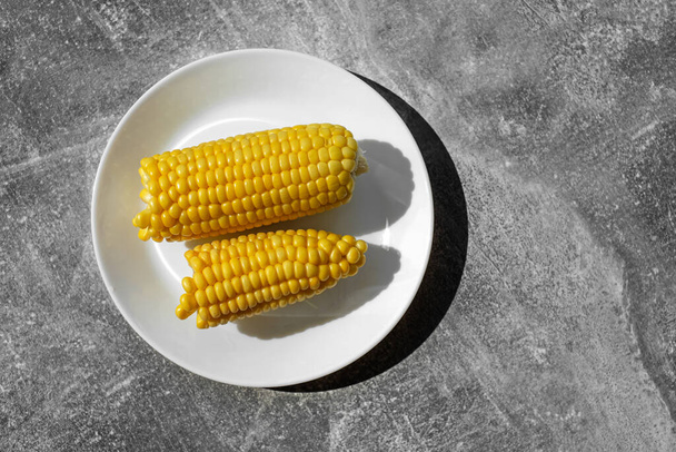 luomu keitetty maissi valkoisella lautasella pöydällä. terveellistä ruokaa. kasvissyöjä aamiainen - Valokuva, kuva