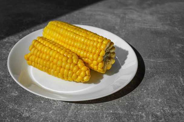 органическая приготовленная кукуруза на белой тарелке на столе. здоровую пищу. вегетарианский завтрак - Фото, изображение