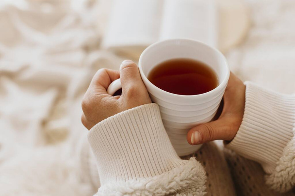 young woman holding cup tea while enjoying winter holidays. High quality beautiful photo concept - Foto, afbeelding