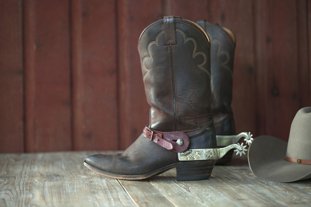 Botas de vaquero, espuelas y sombrero sobre fondo de madera vieja
 - Foto, imagen
