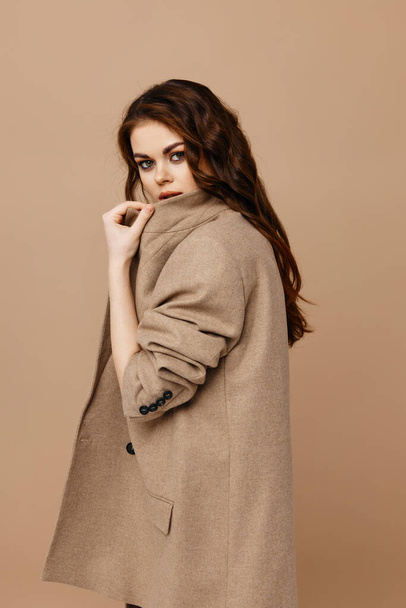 woman in a coat on a beige background. High quality photo - Valokuva, kuva