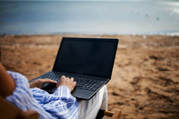 Joven mujer asiática con tablet PC durante las vacaciones en la playa tropical. Freelancer trabajando en laptop tumbado en tumbona. - Foto, imagen