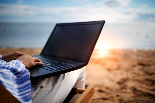 Young asian woman with tablet computer during tropical beach vacation. Freelancer working on laptop lying on sun lounger. - Foto, Imagem