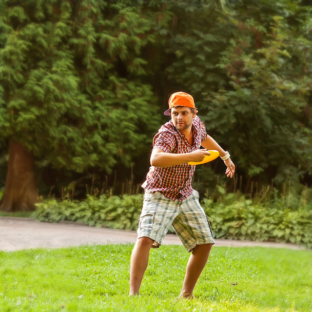 man playing in the park with a plate frisbee - Fotó, kép
