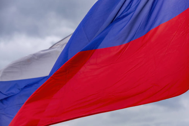 De tricolor staat vlag van Rusland op een bewolkte lucht achtergrond - Foto, afbeelding