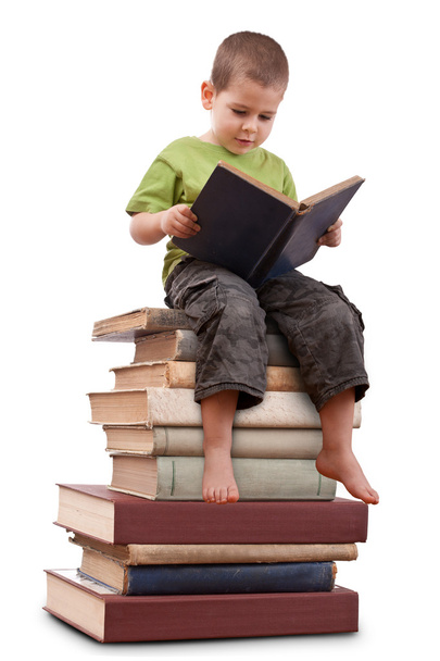 Boy sitting on a big pile of books. - Foto, afbeelding