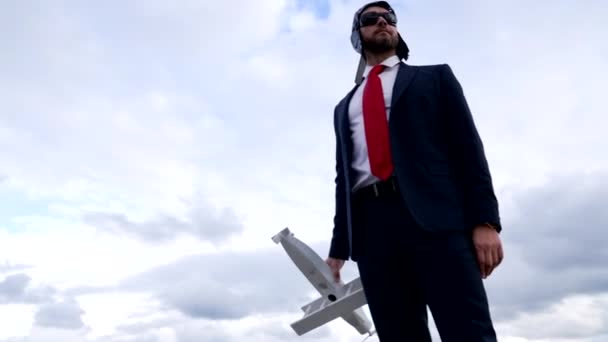 businessman in suit and pilot hat with glasses hold plane, business success - Footage, Video