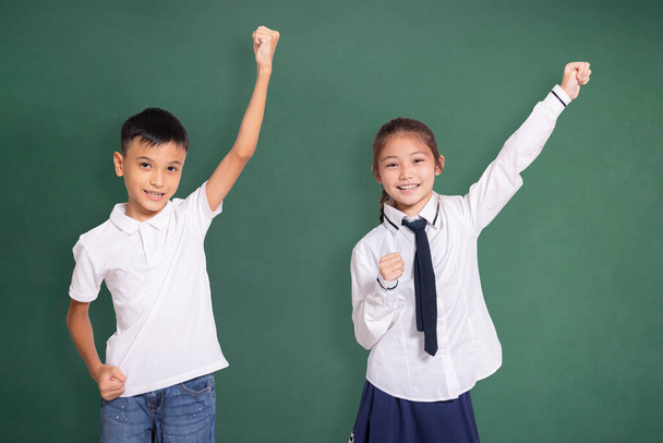 Boldog diák fiú és lány felemeli a kezét - Fotó, kép