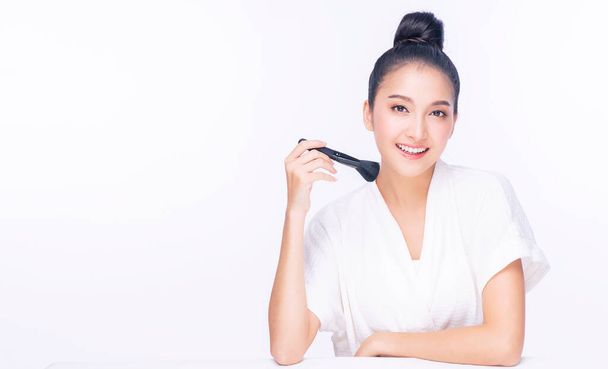 Glamour young woman smile and holding make-u brush with healthy clean and fresh skin while looking at camera over isolated white background. Beauty and cosmetics concept. - Photo, Image
