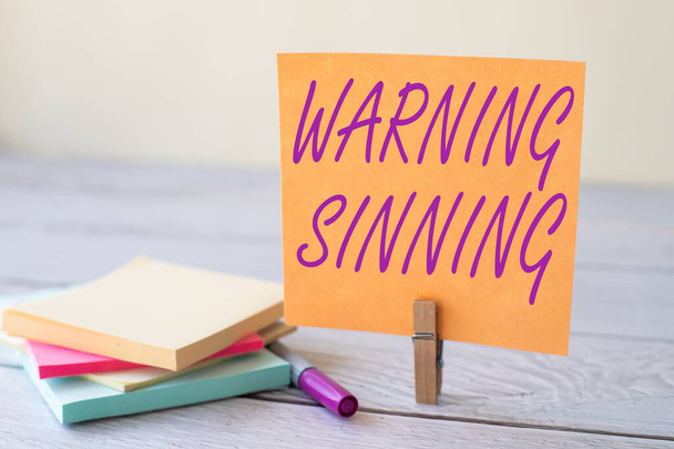 Text sign showing Warning Sinning. Business approach stop the action which is believed to break the laws Blank Sticky Note Laundry Clip Stack Of Colorful Paper Pen Placed On Desk. - Photo, Image