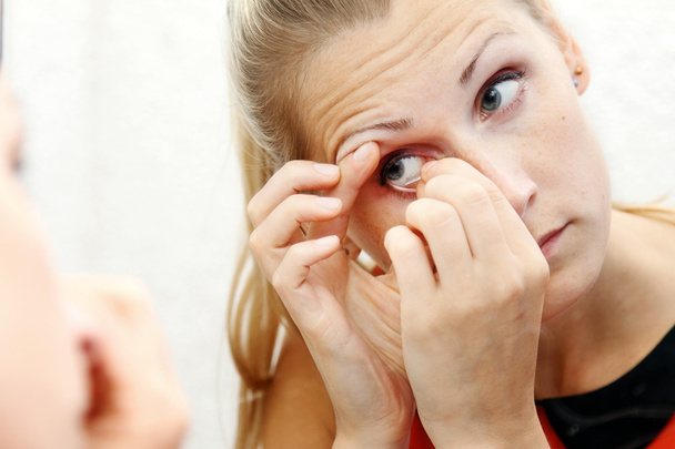 kobieta wyjąć soczewki kontaktowe jej oko - Zdjęcie, obraz