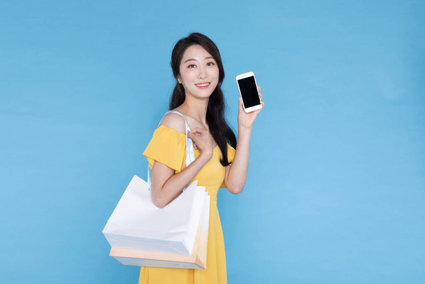 shopping event concept, beautiful Korean Asian woman with shopping bag and smart phone - Photo, image