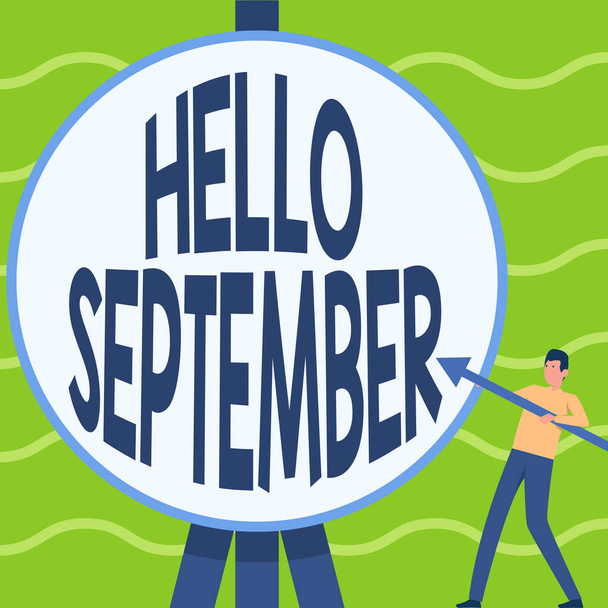 Podpis wyświetlający Hello September. Słowo Napisane na chętnie chce ciepłe powitanie w miesiącu września człowiek stojący trzymając dużą strzałkę wskazując na duży okrągły cel. - Zdjęcie, obraz