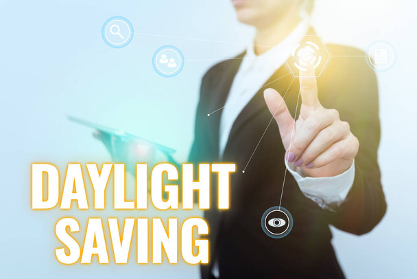 Text caption presenting Daylight Saving. Conceptual photo Storage technologies that can be used to protect data Woman In Suit Holding Tablet Showing Futuristic Interface Display. - Photo, Image