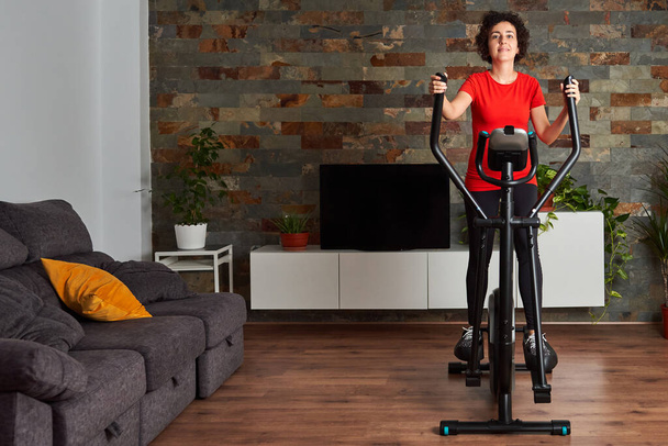 Trening fitness w domu na inteligentnym orbitreku w pomieszczeniach - Zdjęcie, obraz
