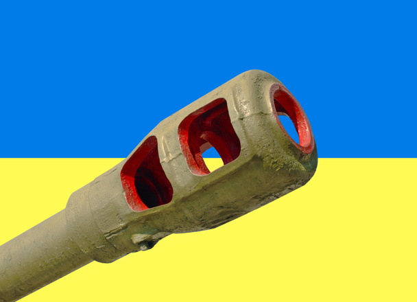 Artillery cannon taken closeup against of Ukrainian flag. - Фото, зображення