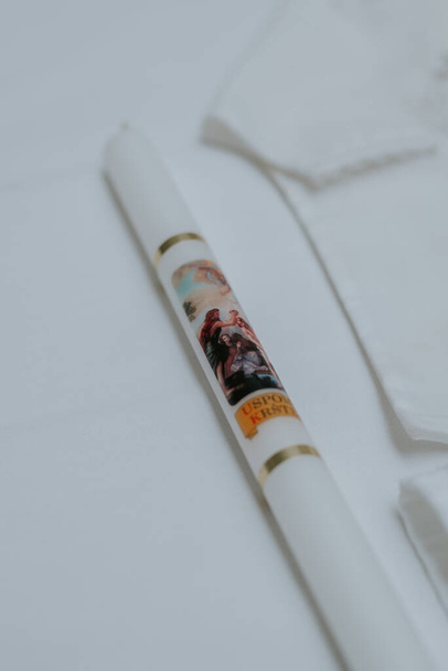 A vertical shot of a religious candle on a white table - Foto, Imagem