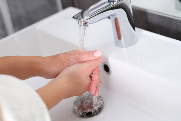 Mulher lava as mãos sob água corrente na pia closeup - Foto, Imagem