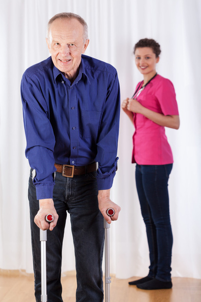 Physiotherapist and  man walking with crutches - Photo, Image