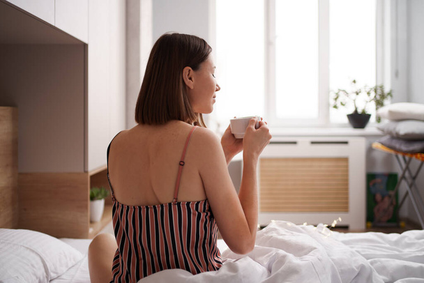 Mujer tomar café en la cama por la mañana - Foto, imagen