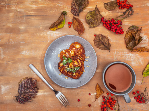Petit déjeuner avec crêpes et thé sur une table aux feuilles d'automne - Photo, image