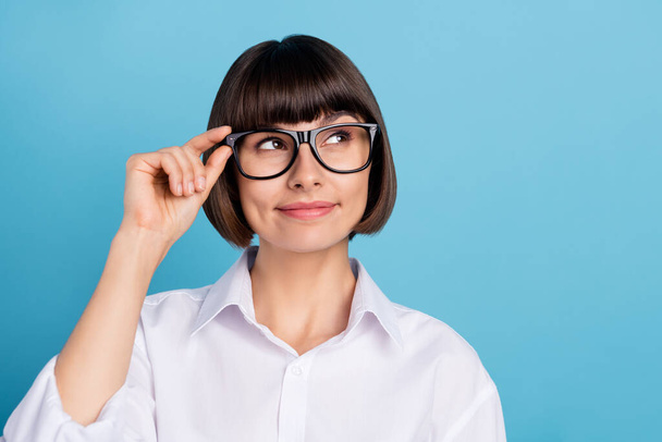 Portrait of attractive cheery minded girl specialist overthinking touching specs copy space isolated over bright blue color background - Foto, Imagen