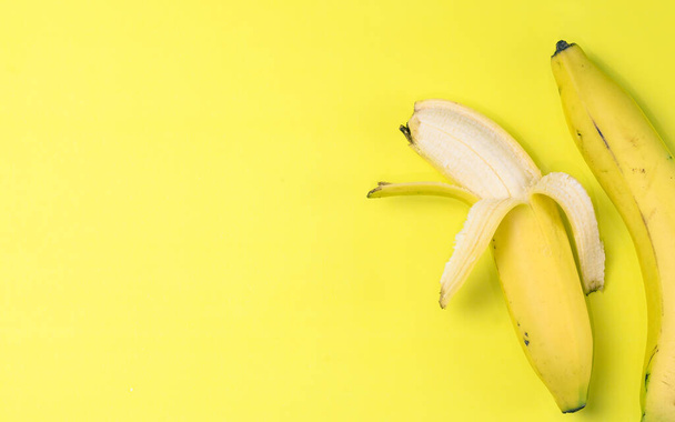 Een bovenaanzicht van bananen geïsoleerd op de gele achtergrond - Foto, afbeelding