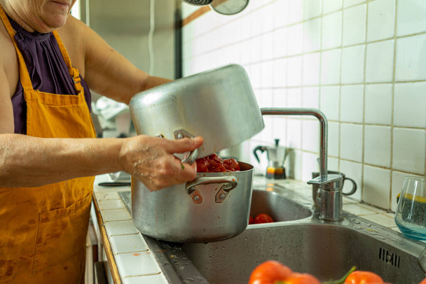 A view of a female preparing a dish from tomatoes - Photo, image