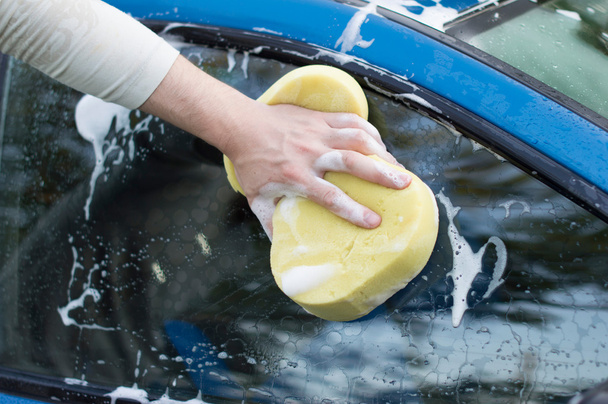 The process of cleaning the hood of the car with the help of shampoo and yellow sponges - Photo, Image