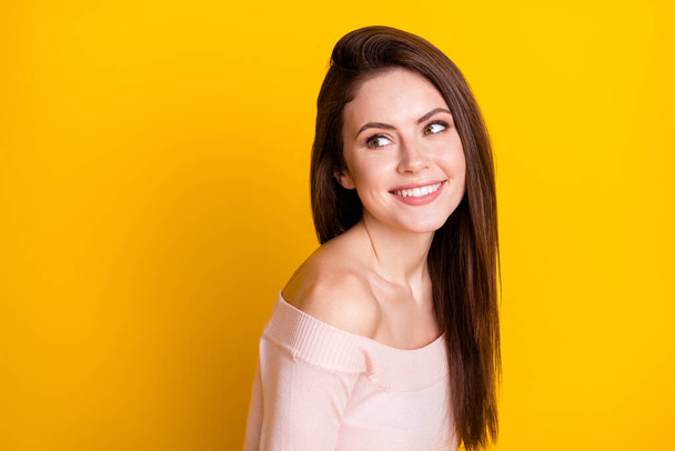 Foto von charmanten netten jungen Frau gekleidet off-shoulder Pullover lächelnd Blick zurück leeren Raum isoliert gelbe Farbe Hintergrund - Foto, Bild