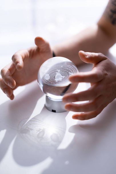 eine Glaskugel mit einer Vorhersage in den Händen eines Astrologen - Foto, Bild