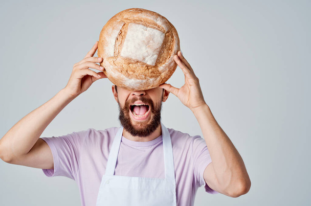 egy szakácsegyenruhás férfi kenyeret tart a kezében konyha Professzionális ipar - Fotó, kép