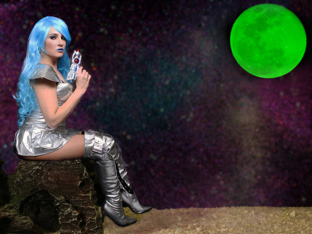 Alien Babe mit blauem Haar und grünem Mond mit Strahlenkanone - Foto, Bild