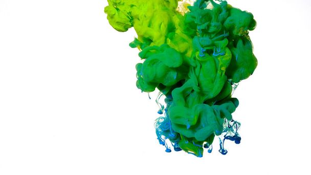 Acrylic blue and green paints are mixed in water. Blue and green watercolor ink in water on a white background. Colored cloud of ink on a white background. Beautiful abstract background. - Foto, Bild