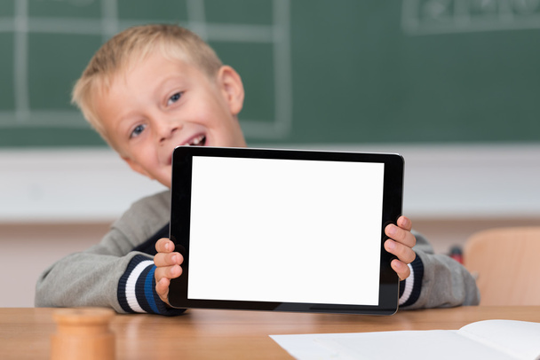 Schoolboy holding up blank tablet - Zdjęcie, obraz