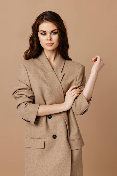 woman in beige coat gesturing with hands cropped view hairstyle makeup - Valokuva, kuva
