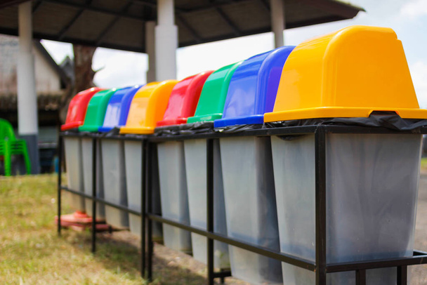Kolorowe pojemniki są umieszczone obok siebie jako pojemniki do sortowania odpadów przeznaczonych do recyklingu i posiadają uniwersalne symbole, które wszyscy turyści muszą zrozumieć, aby oddzielić odpady przed ich unieszkodliwieniem.. - Zdjęcie, obraz