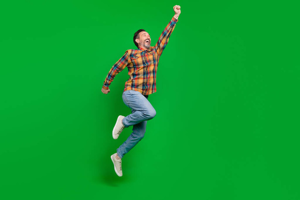 Full length body size view of attractive cheerful man jumping striving isolated over bright green color background - Photo, image