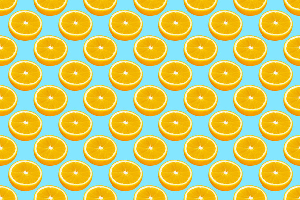 Fatias de laranja fresca sem costura padrão sobre fundo azul, vista superior. - Foto, Imagem