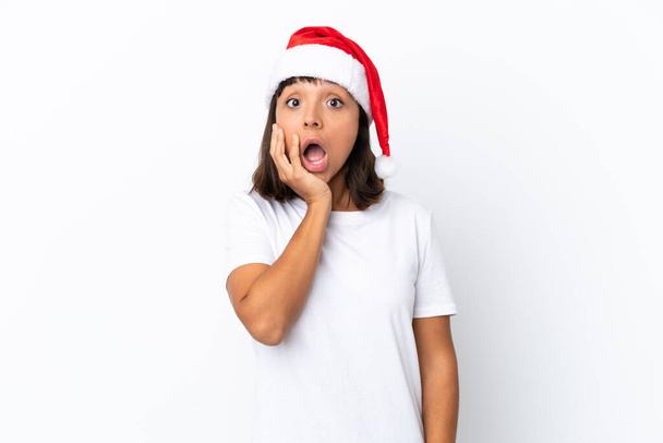 Nuori sekarotuinen nainen juhlii joulua eristetty valkoisella taustalla yllättynyt ja järkyttynyt katsoessaan oikealle - Valokuva, kuva