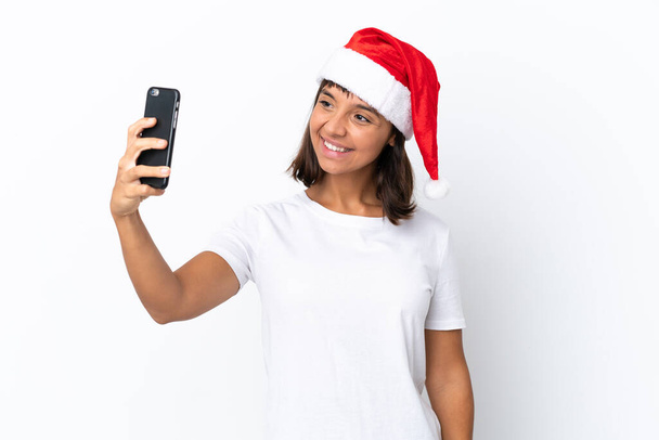 Jeune femme métisse célébrant Noël isolé sur fond blanc faisant un selfie - Photo, image