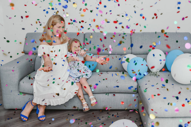 Mother and daughter celebrate birthday and playing confetti. - Foto, Bild