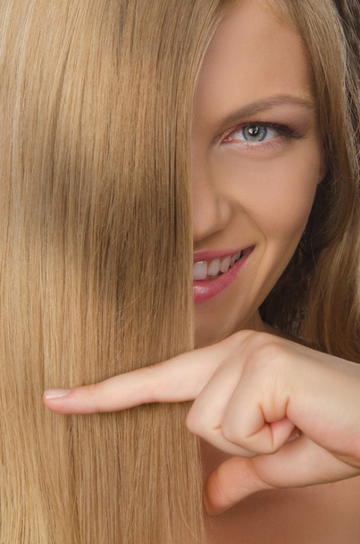 young smilling woman keeps fingers straight hair - Photo, image
