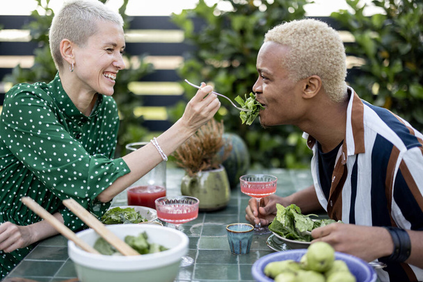 Mulher alimentando salada para namorado durante o jantar - Foto, Imagem
