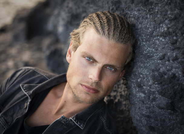 A portrait of an attractive blue-eyeblond young man with a unique hairstyle - Foto, imagen