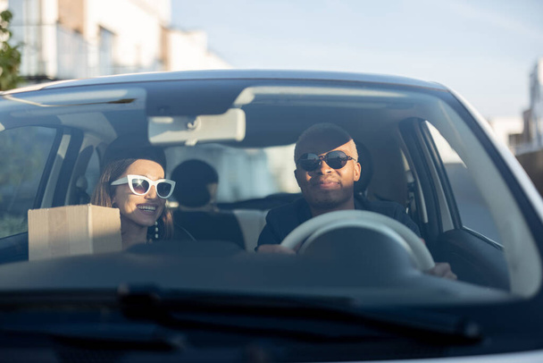 Багаторасова пара їде в машині в сонячний день
 - Фото, зображення