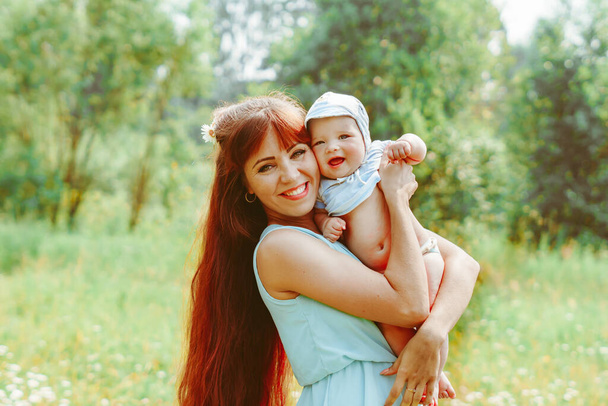 Genç bir anne bebeği kollarında kaldırdı - Fotoğraf, Görsel